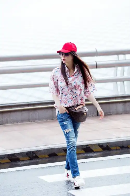 伊能静最新机场照,一身粉色印花衬衫搭配牛仔裤,腰挎小包,青春活力超