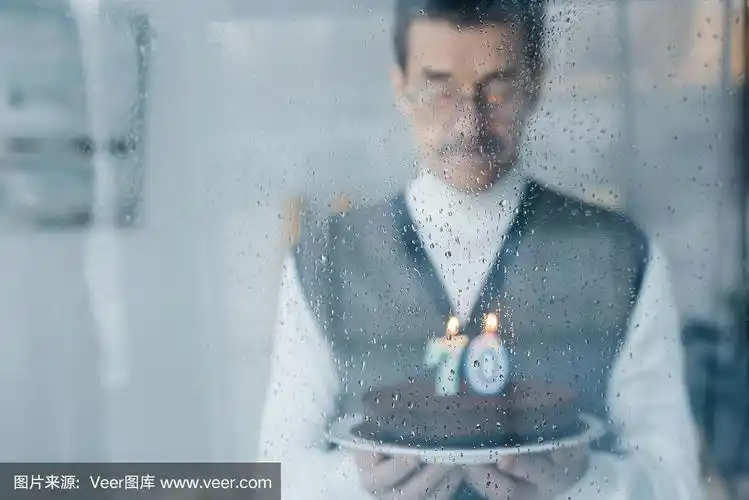 有选择的焦点与悲伤的老人拿着生日蛋糕的背景雨点窗户