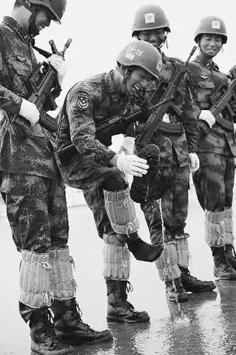 乐观的阅兵队员在雨中训练时,倒出靴子中的积水.卢炳广摄