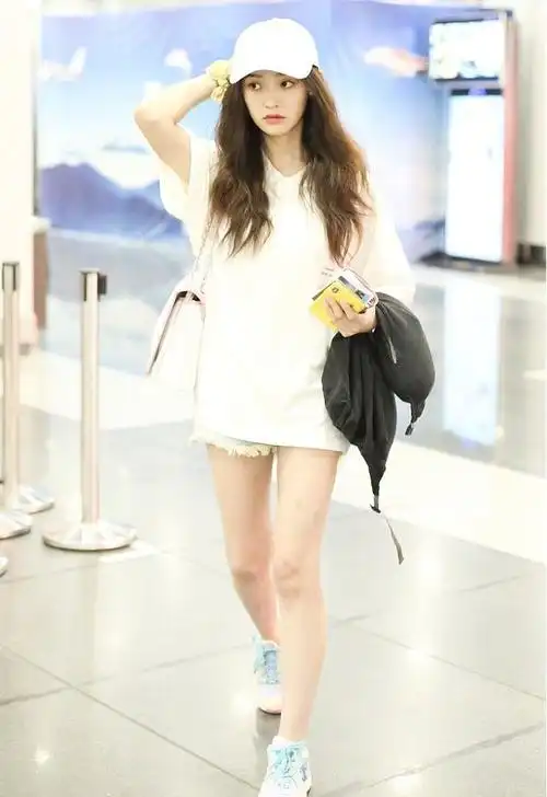 林允开心现机场鸭舌帽配绿色露胃装斜背香奈儿包包太吸睛