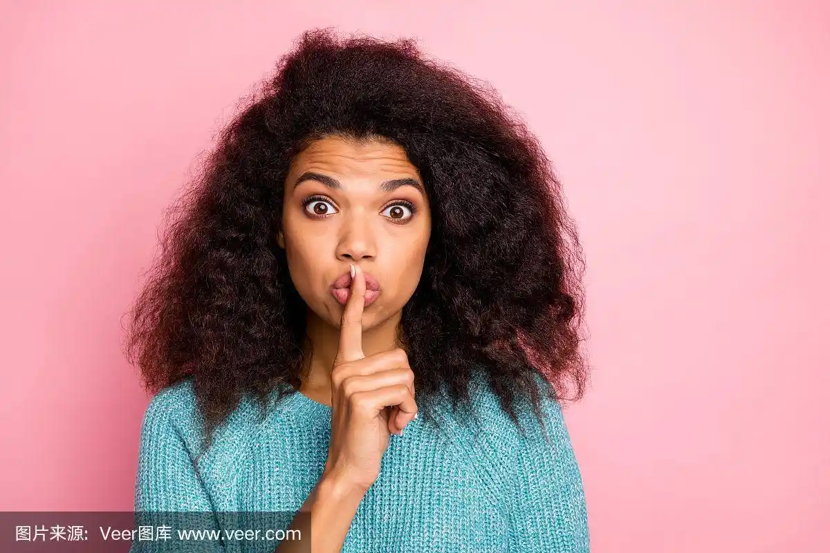 照片的女人在蓝色毛衣显示你嘘手势停止你的说话触摸嘴唇与食指表达