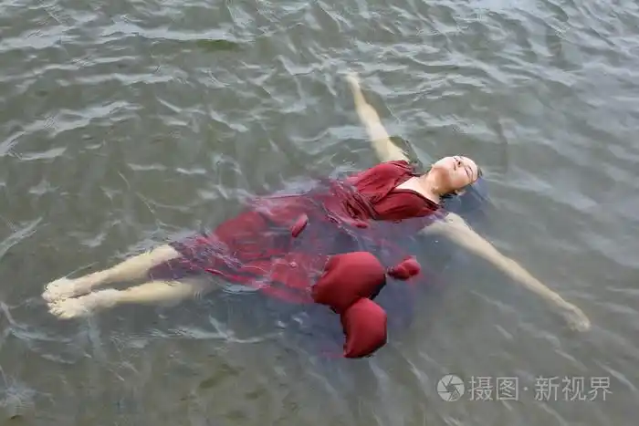 年轻美女穿红裙子躺在室外水淹死