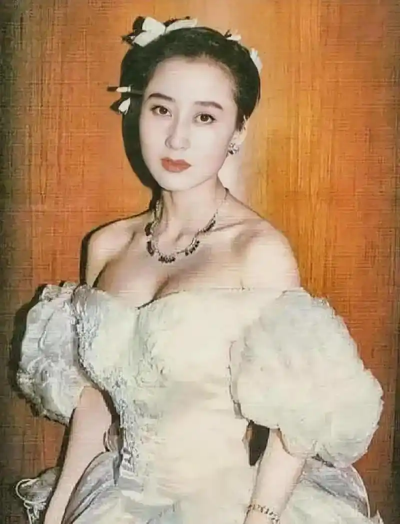 80年代,利智颜值巅峰期的照片,画面中她穿着白色的露肩礼服,拥有着