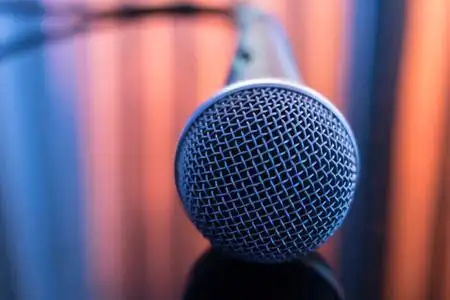 歌手音乐会舞台手拿着麦克风唱歌和演示或配音照片