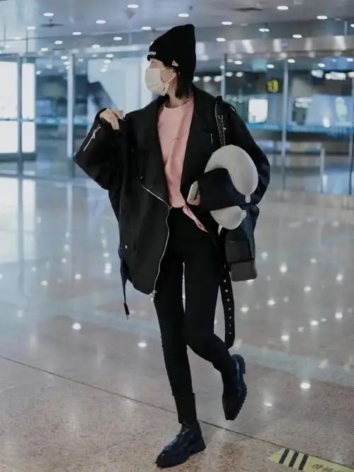 乔欣机场私服look,身穿黑色机车夹克下搭修身牛仔裤与切尔西短靴,头戴