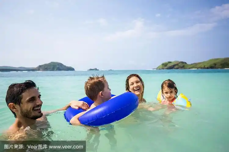 快乐的父母和他们的孩子在海里游泳的时候玩得很开心.