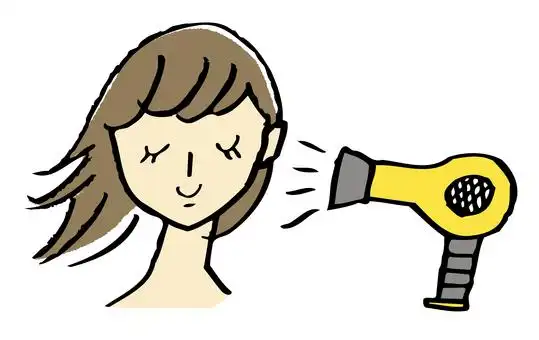 一个女人用吹风机吹乾头发