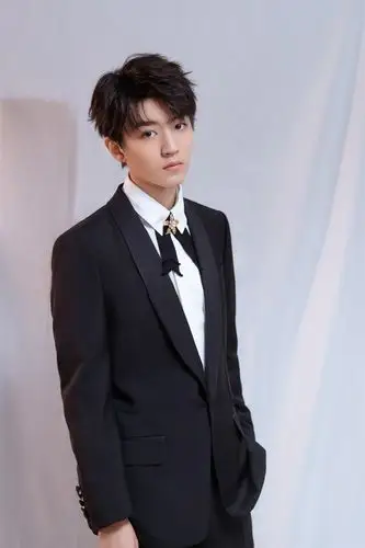 王俊凯身着黑色西装搭配花叶领结亮相,整体造型凸显绅士魅力又不失