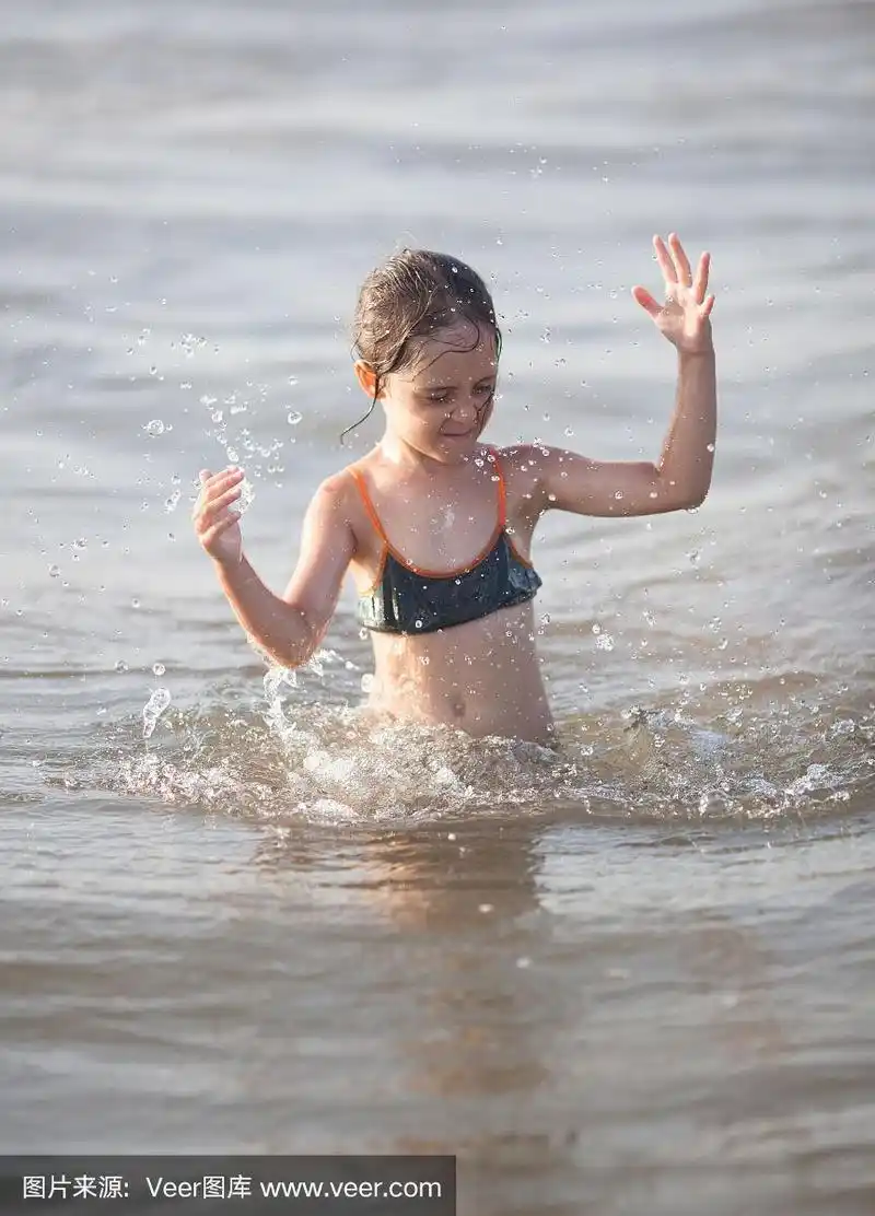 小女孩在海里玩耍和游泳