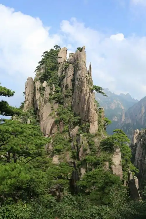 蓝天白云挂在天边,陪伴独立山峰顶天立地.