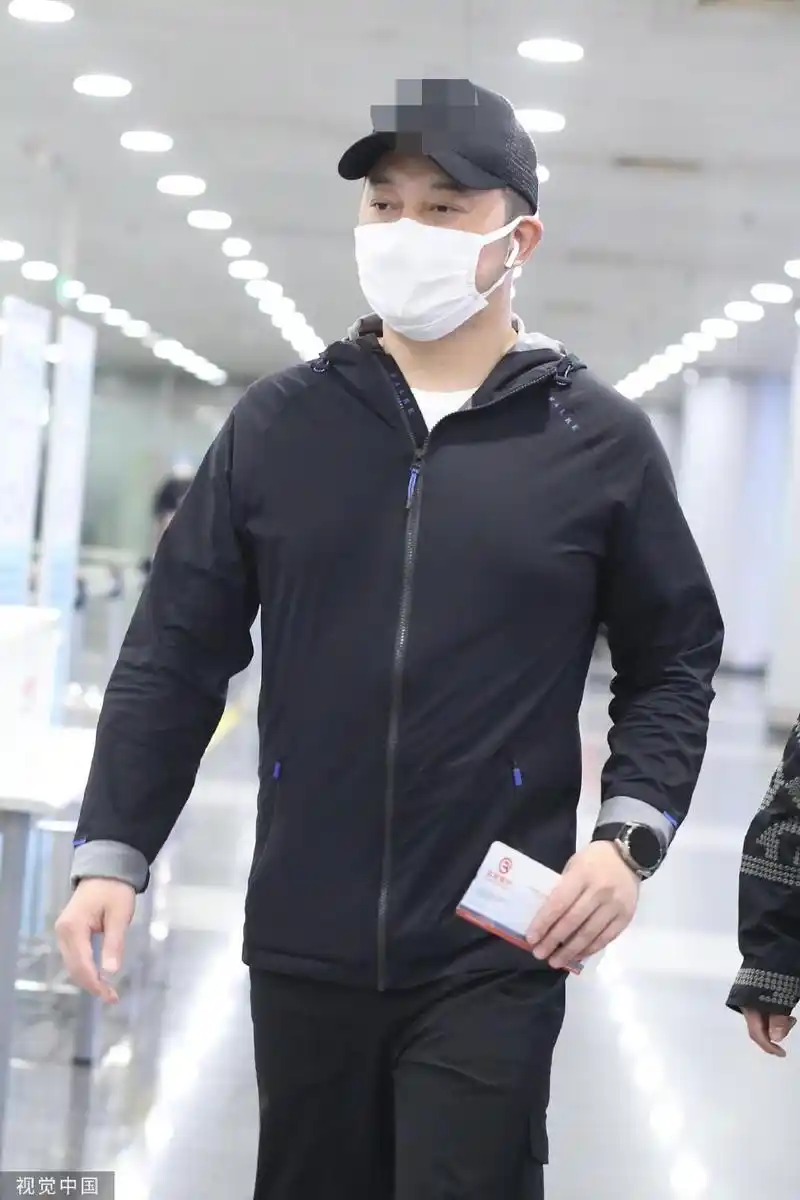 组图:沙溢全黑look现身机场 长袖运动外套搭棒球帽低调随性