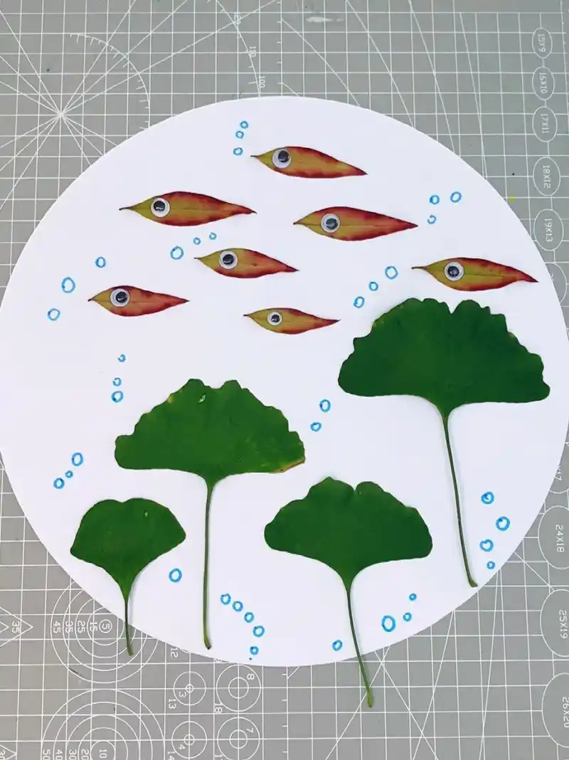 用树叶贴一幅海底世界的小鱼群吧