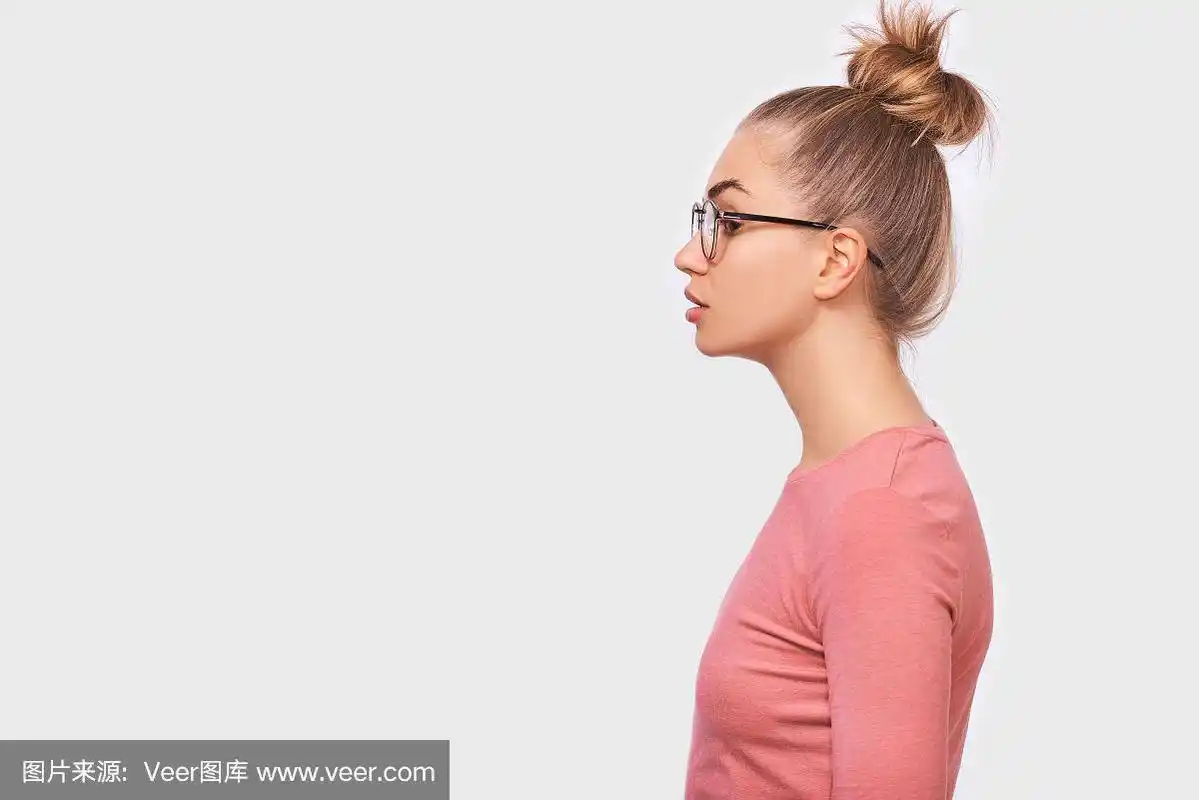 侧视图肖像的年轻漂亮的女人戴眼镜,望向空白的拷贝空间,孤立的白色