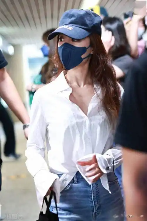 蔡依林白衬衫 牛仔裤 运动鞋 棒球帽 黑色手提包简单时尚_上海_机场