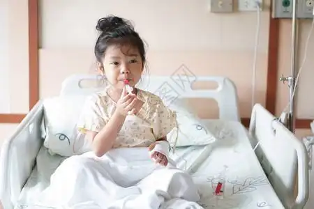 亚洲儿童可爱或小女孩流感病患者在病房床上用盐水注射泵吃或服用甜