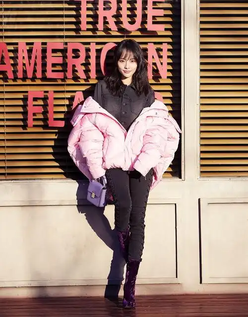 写真中,张嘉倪身穿冬日最in款粉色oversize羽绒服,搭配黑色绑带牛仔裤