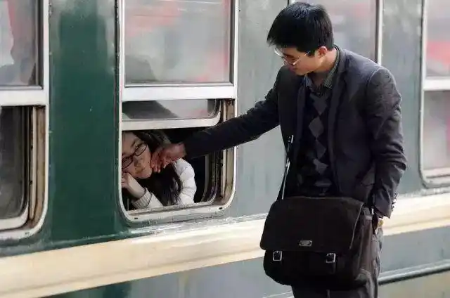 手抚摸着女友的脸还不忍离去男子把女友送上火车一对情侣依依不舍亲情