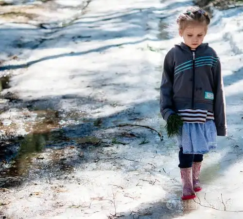 严肃的小女孩站在冰上春天温暖的日子