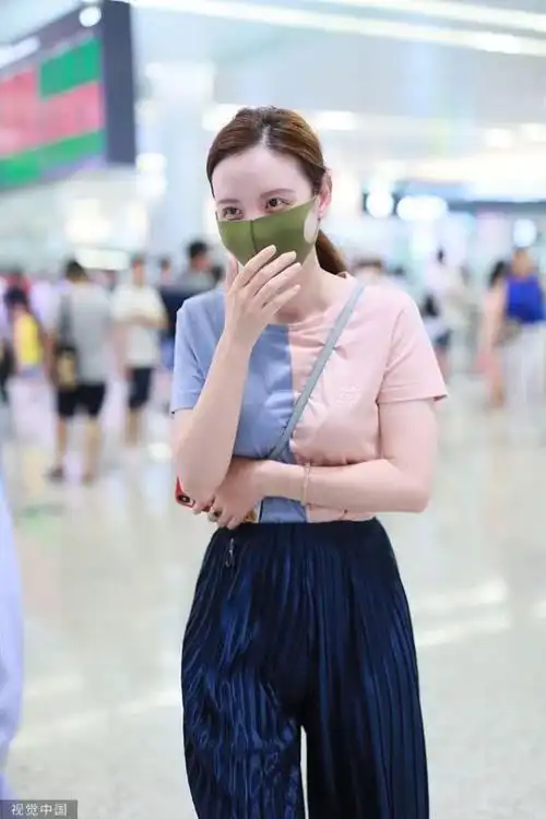 张萌机场照,圆领t恤配上阔腿裤,背包带勾出完美身材