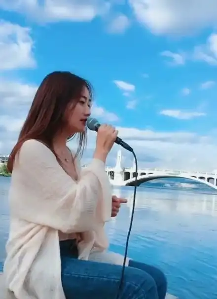 美女海边唱歌,风景优美,简直是画中的美人儿!