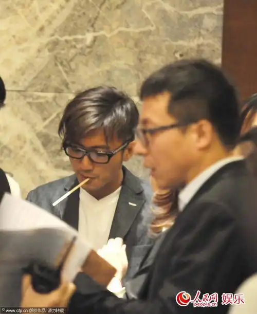 老烟枪谢霆锋在酒店大堂无法抽烟,嘴里叼着小棒子解瘾,与霍汶希聊天