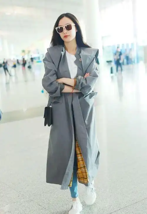 女明星机场出行,身穿灰色风衣,穿搭时尚尽显独特魅力