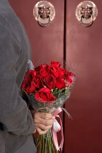 年轻男子手捧鲜花等候