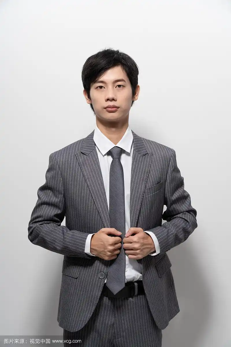 在白色背景前穿西装的男人