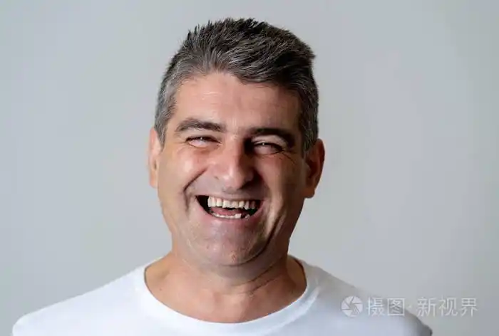 特写肖像的一个有吸引力的中年男子有乐趣和寻找快乐愉快的微笑和嘲笑