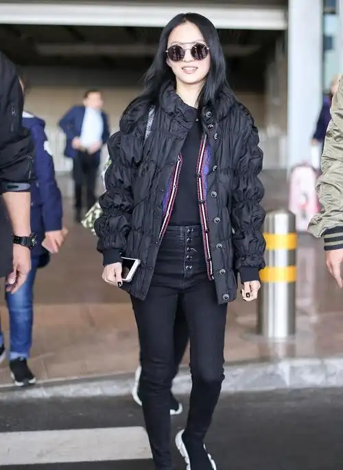 那英黑棉服叠穿红卫衣挽老公胳膊走机场老夫老妻也爱秀恩爱