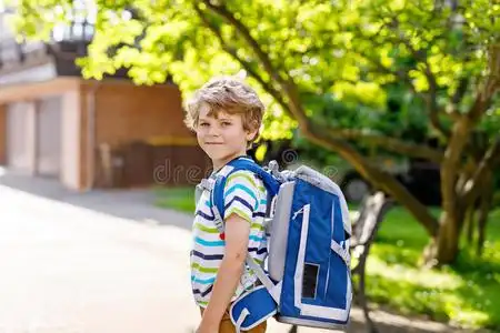 小孩书包小的小孩男孩和学校书包向第一一天向学校照片