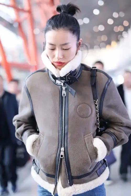 刘雯穿棕色毛绒外套搭配牛仔裤现身 自推行李行走间星范十足