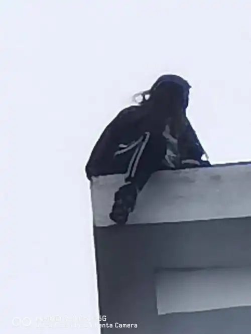 情绪十分激动双腿已悬空晃动在外边女子坐在楼顶的边缘坐在了楼顶上将