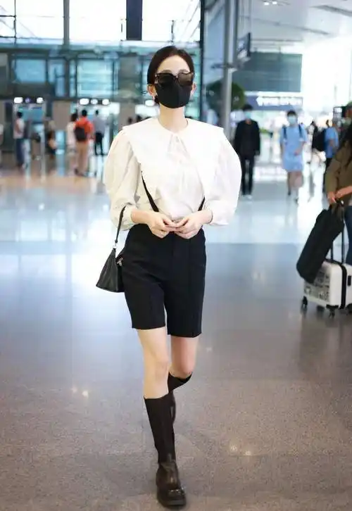 古力娜扎穿白色衬衫搭配黑色西装中裤,脚踩黑色高筒靴,简约大气_上海