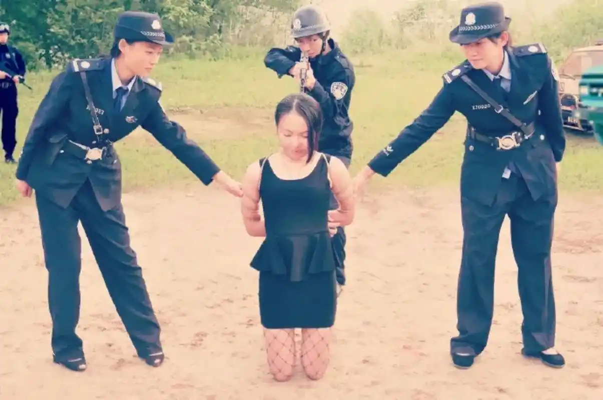 照片中的女犯人,一头乌黑的长发,留着空气刘海,她穿着黑色的套裙,腿