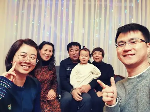 "小小"被姥爷抱在怀里,两个孩子用手机自拍,留下19年春节的全家福