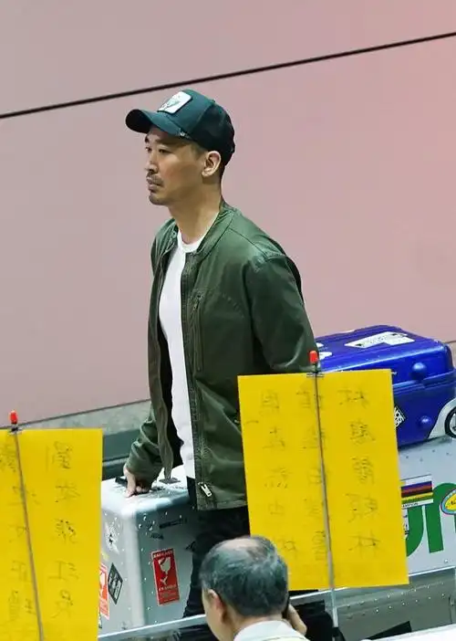 台北,黄立行独自现身机场,他身穿军绿色外套,戴棒球帽休闲范十足,满脸