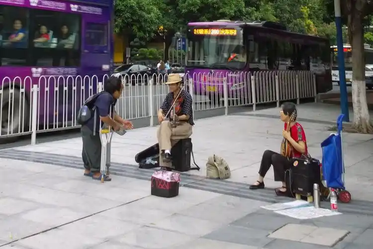 2,闹市里,街头卖艺人刚摆开摊子,乞丐就上前讨要,卖艺人似乎一下子没