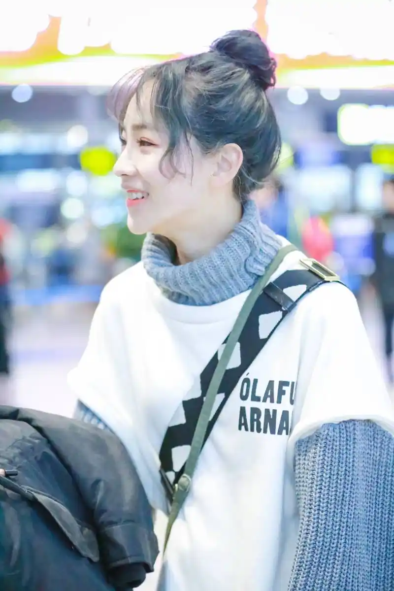 蒋申穿白色短袖卫衣内搭蓝色高领毛衣现身机场,扎丸子头皮肤白皙