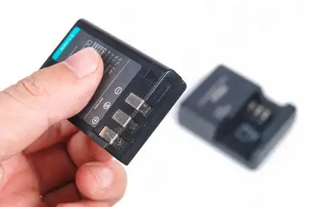 相机电池和充电在白色背景上照片