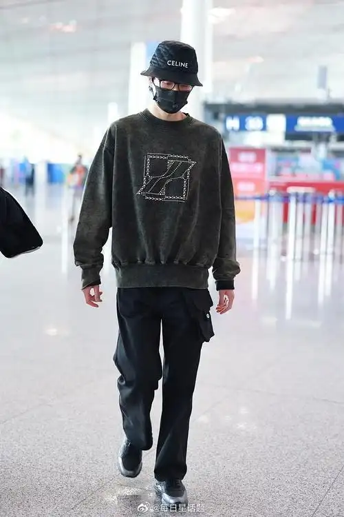 2022年4月9日,北京,许嵩穿墨绿色卫衣戴celine渔夫帽现身机场,帅气