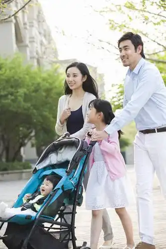 年轻家庭推着婴儿车散步