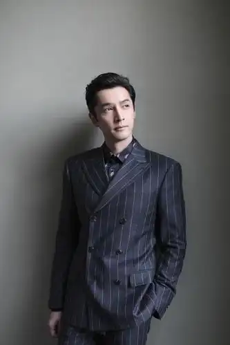 胡歌身穿深色条纹西服出席活动,清爽干练,帅气十足