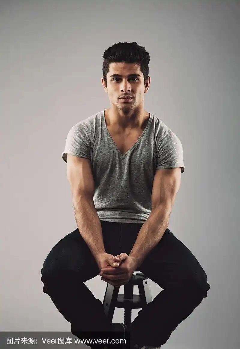 肌肉发达的年轻男模特坐在凳子上
