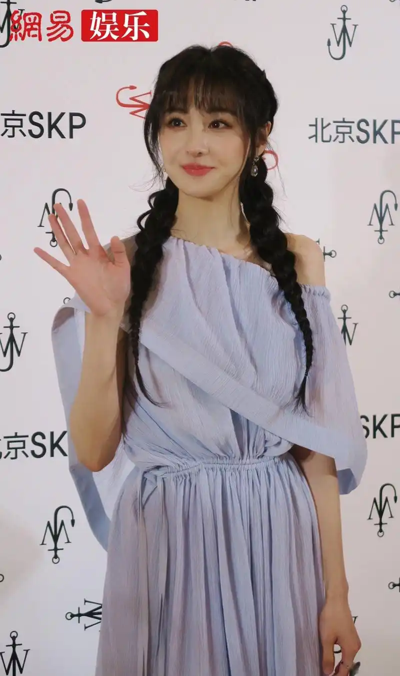 郑爽身穿一袭蓝色纱裙搭配麻花辫亮相某时尚活动,表情俏皮可爱,是吃糖