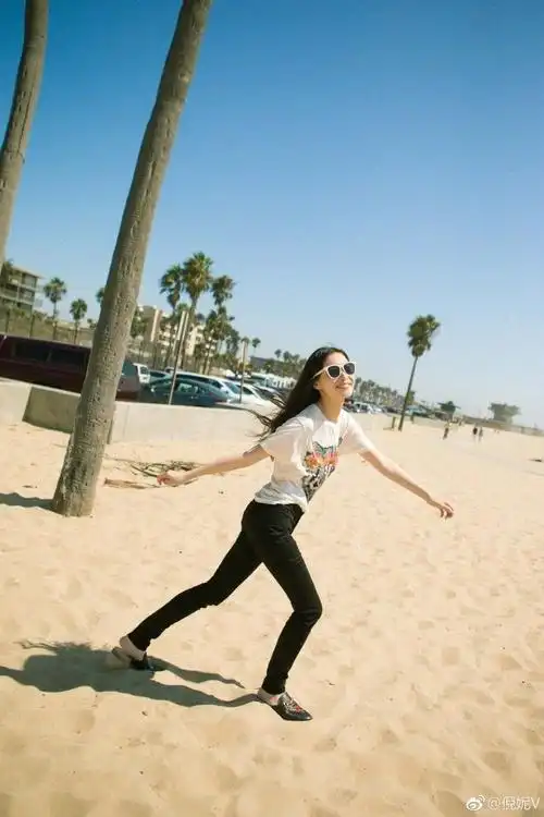 倪妮赤脚漫步沙滩笑容满面