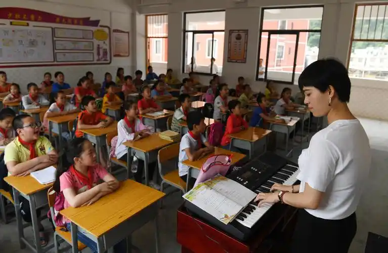 下坳镇深圳宝安红星小学,来自深圳的支教老师梁美玲在给学生上音乐课