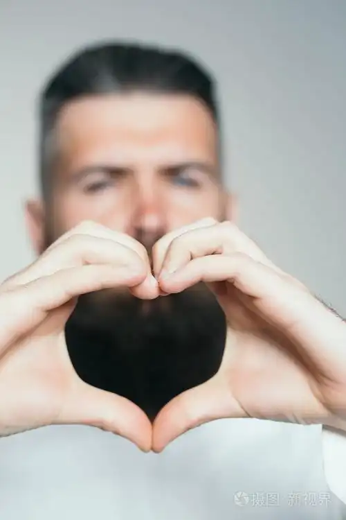 大胡子的男人手在心的形状