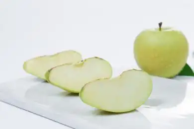 放在白背景上盘子里切开的青苹果