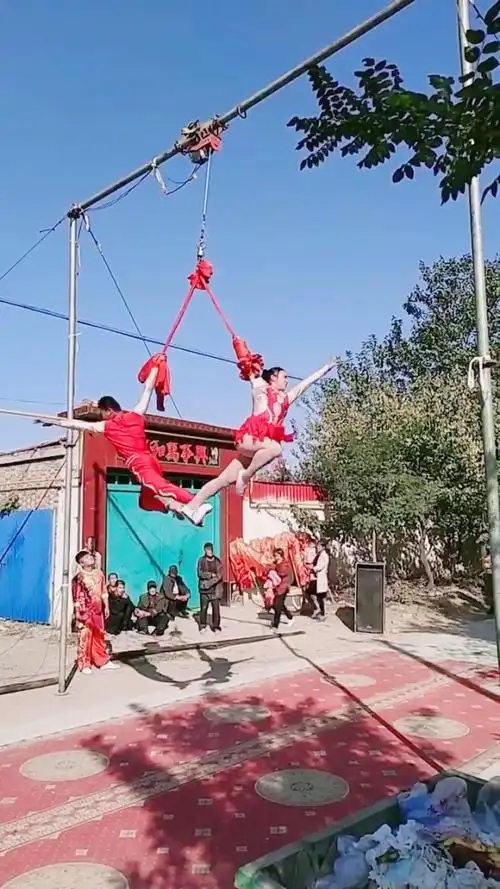 民间艺术农村街头杂技表演,高空绸吊双人舞.